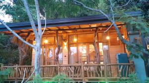 a cabin in the woods with a deck with chairs at Eco Cabins Hideaway Ella in Ella