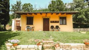 a small yellow house with a yard at IL Podere del nonno in Ripatransone