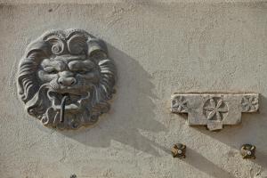 a lion gargoyle on the side of a building at Casal Sikelio in Cassibile