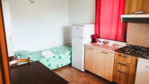 a small kitchen with a refrigerator and a bed at IL Podere del nonno in Ripatransone +12 photos