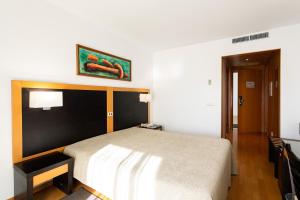 a bedroom with a bed and a picture on the wall at Antillia Hotel in Ponta Delgada +29 photos
