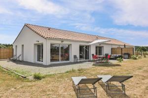 a small white house with a table and chairs at L'échappé Belle du Bessay in Avrillé