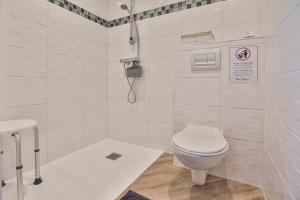 a white bathroom with a toilet and a shower at Gite du Bord de mer in Avrillé +11 photos