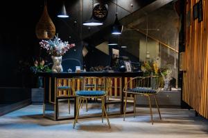 a bar with three chairs and a counter with flowers at H Boutique Peña Parda in La Herradura