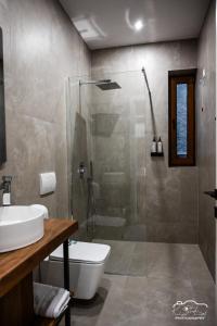 a bathroom with a shower and a toilet and a sink at Rubin Boutique in Korçë