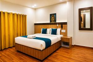 a bedroom with a large bed and a yellow curtain at Hotel City Center in Bhairāhawā