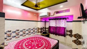a bedroom with a bed with a pink and black wall at Hotel Protima guest inn in Digha +9 photos
