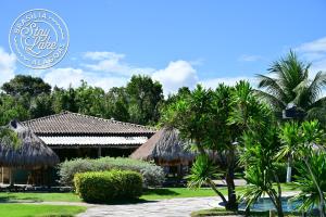 a resort with palm trees in front of a building at Studio Iloa Vista Piscina 004V in Barra de São Miguel