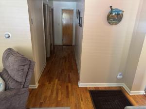a living room with a couch and a hallway at Dash House in Deadwood