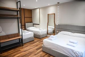 a hotel room with three beds and a television at Rubin Boutique in Korçë