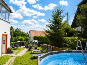 a backyard with a swimming pool and a yard with chairs at Urlaubsmagie Ferienwohnung Wiesengrün - direkt am Wanderweg - für 6P - W6 in Sebnitz