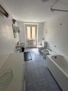a bathroom with two toilets and a tub and a sink at La Locanda del Viandante in Mendrisio