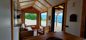 a tiny house with a view of a living room at Tiny Merak - Ramsko jezero in Kovačevo Polje