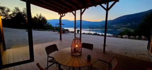 a table and chairs on a deck with a chandelier at Tiny Merak - Ramsko jezero in Kovačevo Polje