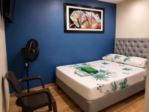 a blue bedroom with a bed and a fan at Hostal Avanza in Cali