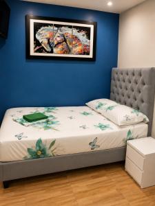 a bed in a room with a blue wall at Hostal Avanza in Cali +35 photos