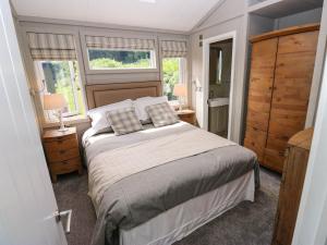 a bedroom with a bed and two windows at Dales Retreat in Skipton