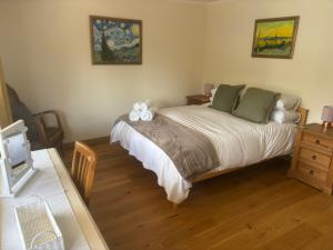 a bedroom with a bed and a wooden floor at The Owlery in Fort William