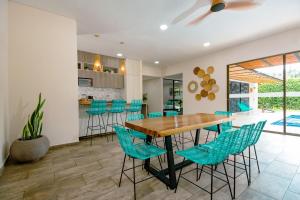 a dining room with a wooden table and blue chairs at Finca los Colores Villavicencio in Villavicencio