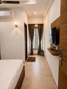 a hotel room with a bed and a television at Nakshatra Boarding and Lodging in Mangalore International