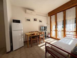 a kitchen and dining room with a refrigerator and a table at Residenza Emilia in Lido degli Estensi