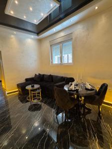a living room with a black couch and a table at A&S apartmani 2 in Smederevo