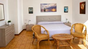 a bedroom with a bed with two chairs and a table at Villa Stasi B&B in Leuca