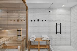 a bathroom with a shower and a bench with towels at Manor at Brighton in Brighton +39 photos