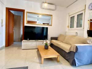 a living room with a couch and a table at Side Sea View Apartment in Neoi Epivates