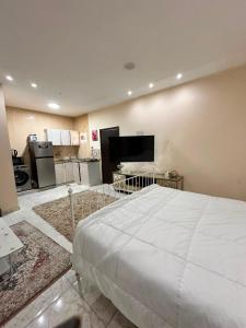 a large bedroom with a large bed and a flat screen tv at luule in Al Ain