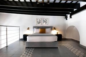 a bedroom with a bed and two night stands at Casa Las Ruinas Boutique Hotel in San Juan