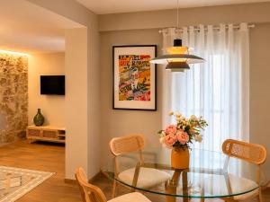 a dining room with a glass table and a vase of flowers at Casa Rosetta Boutique in Xàtiva