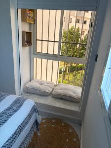 a bedroom with a window with two pillows and a bed at perle rare plage des Nations in Sidi Bouqnadel