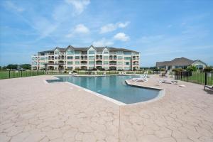 a large apartment building with a pool in front of it at Lakefront Paradise with Stunning Views! in Corsicana