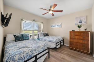 a bedroom with two beds and a ceiling fan at Lakefront Paradise with Stunning Views! in Corsicana +14 photos