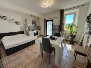 a bedroom with a bed and a table and a kitchen at QUEEN appartamenti e camere in Campofilone
