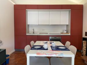 a kitchen with a table and chairs and a kitchen with white cabinets at Casa Ficcanaso in Caorle