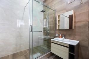 a bathroom with a glass shower and a sink at Yaniv Apartments Oniru in Lagos +38 photos