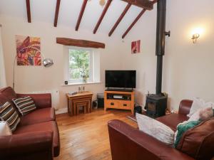 a living room with a couch and a flat screen tv at The Spinney in Milnthorpe