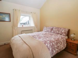 a bedroom with a bed and a window at The Spinney in Milnthorpe
