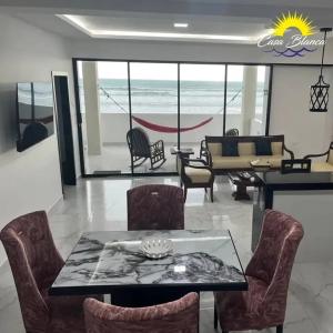 ein Wohnzimmer mit Tisch und Stühlen und dem Meer in der Unterkunft Via marina in Same