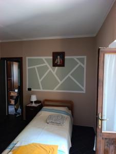 a bedroom with a bed with a picture on the wall at La casa dei Ruc in Capo di Ponte