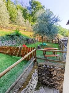 a wooden fence with a bench in a park at La casa dei Ruc in Capo di Ponte