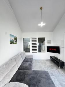 a living room with a couch and a tv at Villa Alizé Kreyol in Le François