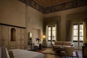 a bedroom with a bed and a living room at Porta Rossa Hotel Firenze, Colbert Collection in Florence