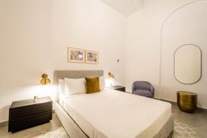 a white bedroom with a bed and a mirror at Casa Las Ruinas Boutique Hotel in San Juan