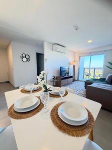 a living room with a table with plates and wine glasses at Apartamento completamente equipado! Con Parking! En Paraná Playa Deptos! in Encarnación