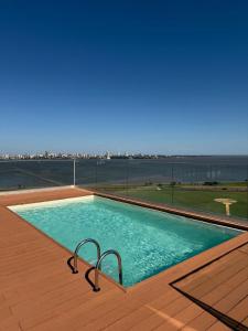 a swimming pool with a view of the water at Apartamento completamente equipado! Con Parking! En Paraná Playa Deptos! in Encarnación