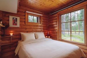 a bedroom with a bed in a log cabin at Northern Nest by Elys Collection in Kittilä