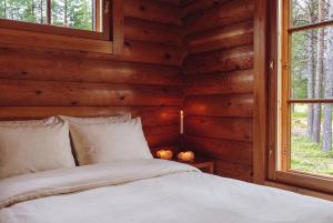 a bed in a log cabin with a window at Northern Nest by Elys Collection in Kittilä